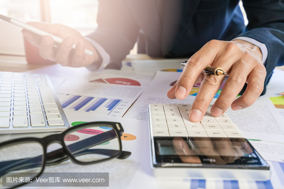 商人或会计工作计算器计算业务数据的概念。会计、投资顾问咨询财务报告的情况,并在办公室策划营销计划。